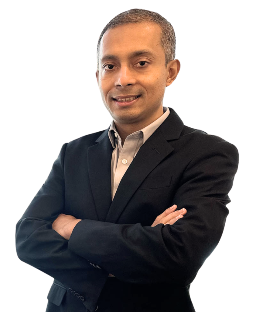Professional portrait of a man in a dark suit with arms crossed, smiling slightly against a black background, looking confident.